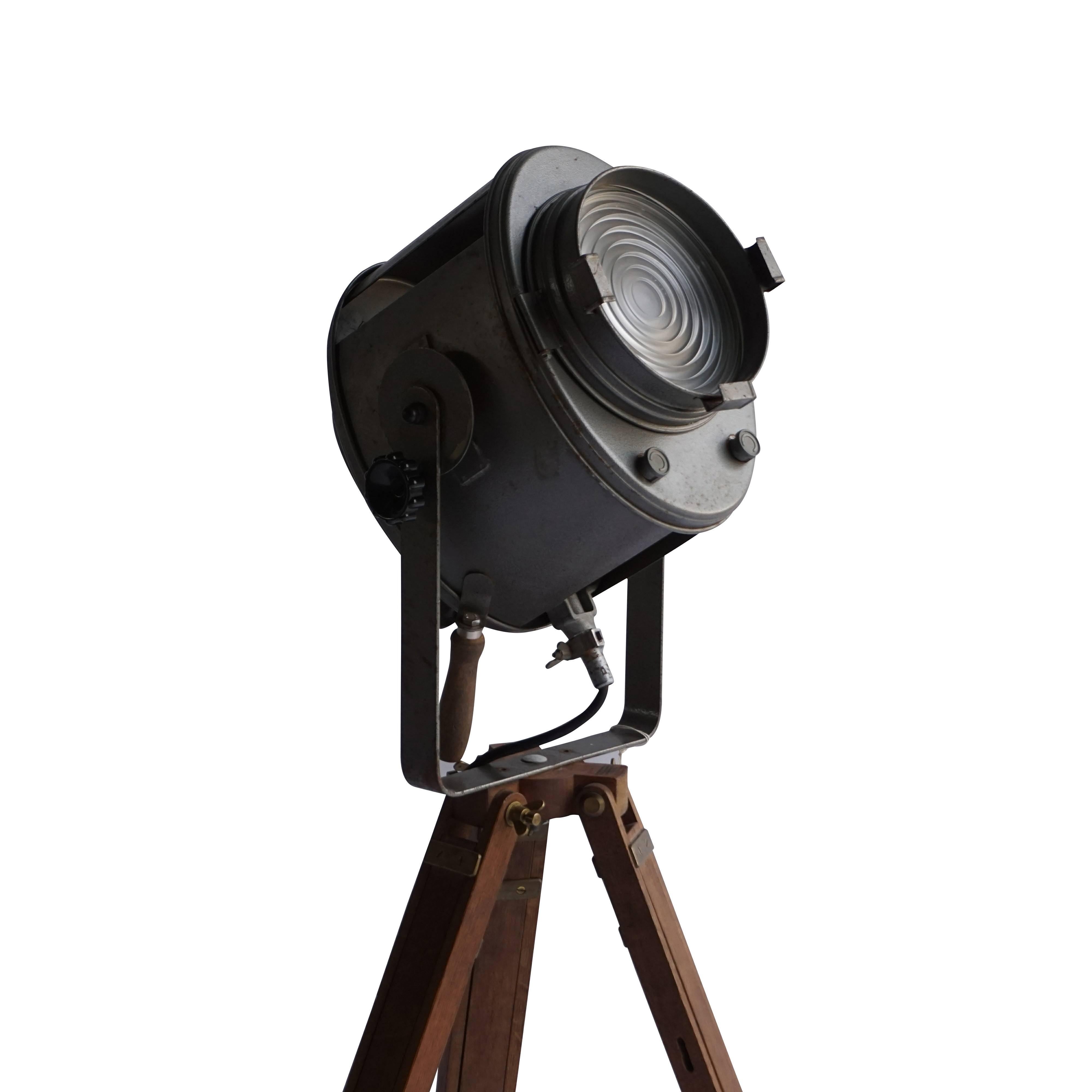 An A.E. Cremer, Paris, signed Parisian theater spotlight on a wooden vintage stand. The light is still for further use and all mechanics are functioning. Paris, 
circa 1930.