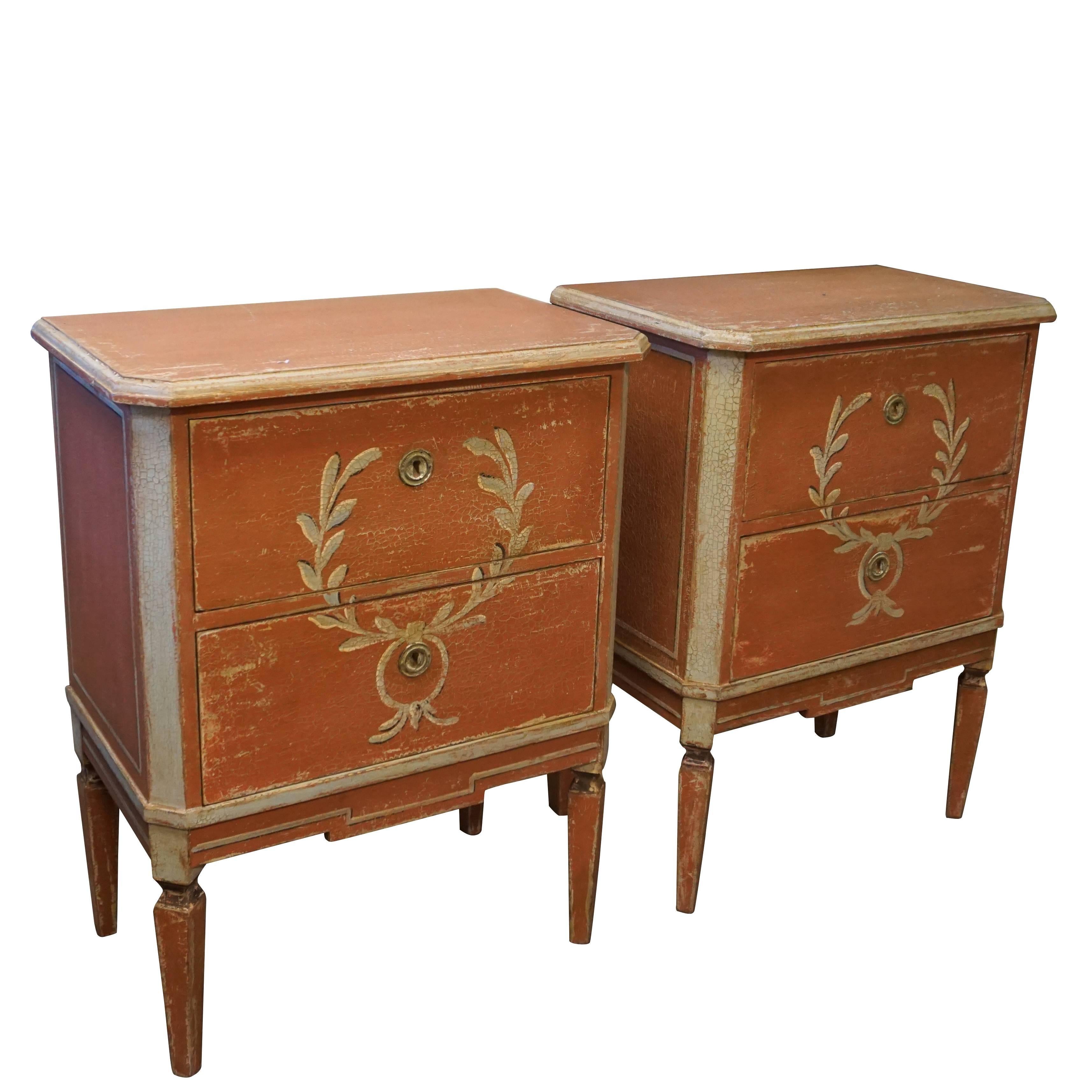 A pair of petite restored Gustavian style chests with two drawers each on tapered legs with an hand-painted centered Empire decor on the front surface,
Sweden, Scandinavia.