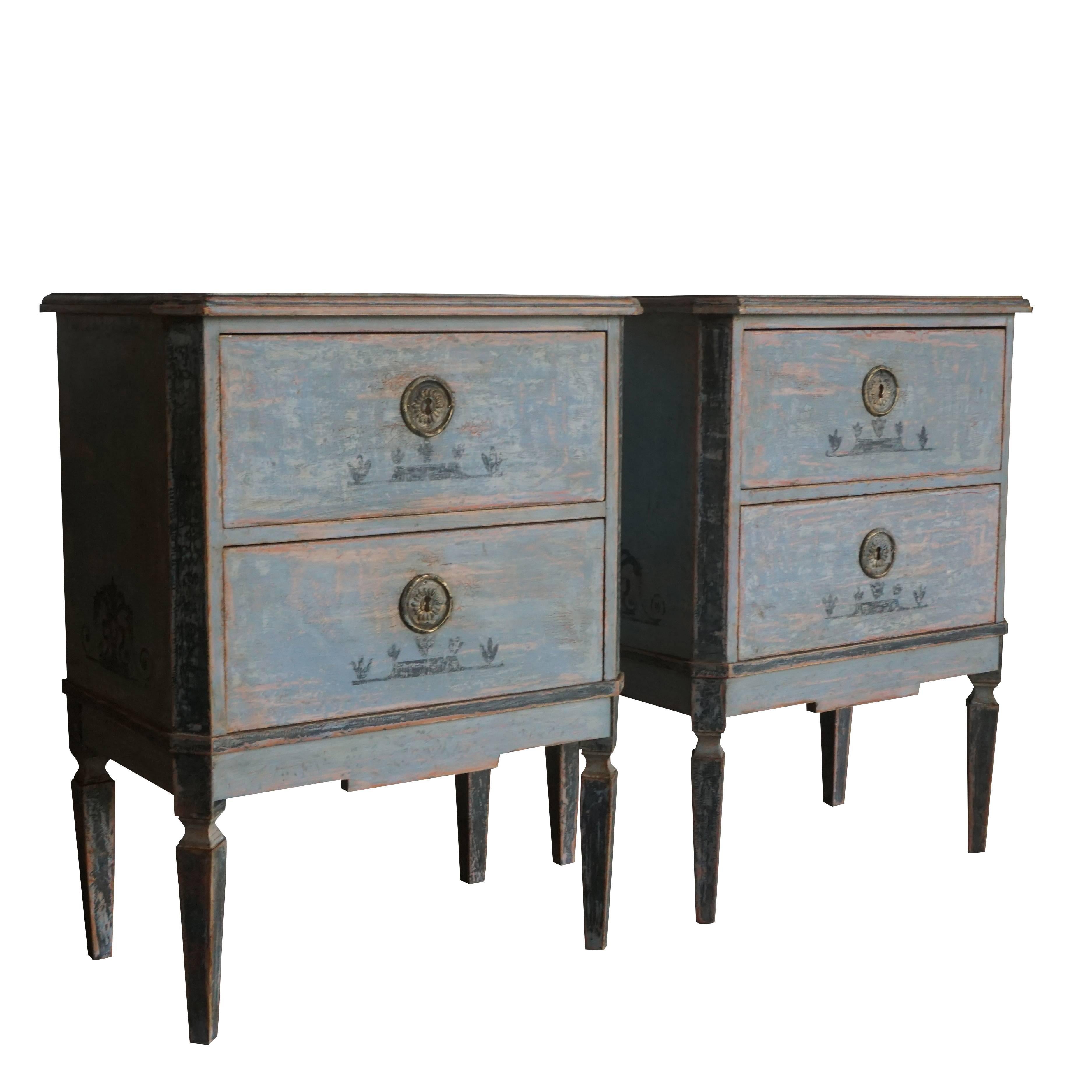A pair of restored Swedish chests of drawers in a light blue-grey painted finish with hand-painted decoration, antique hardware and fluted legs, circa 1870.