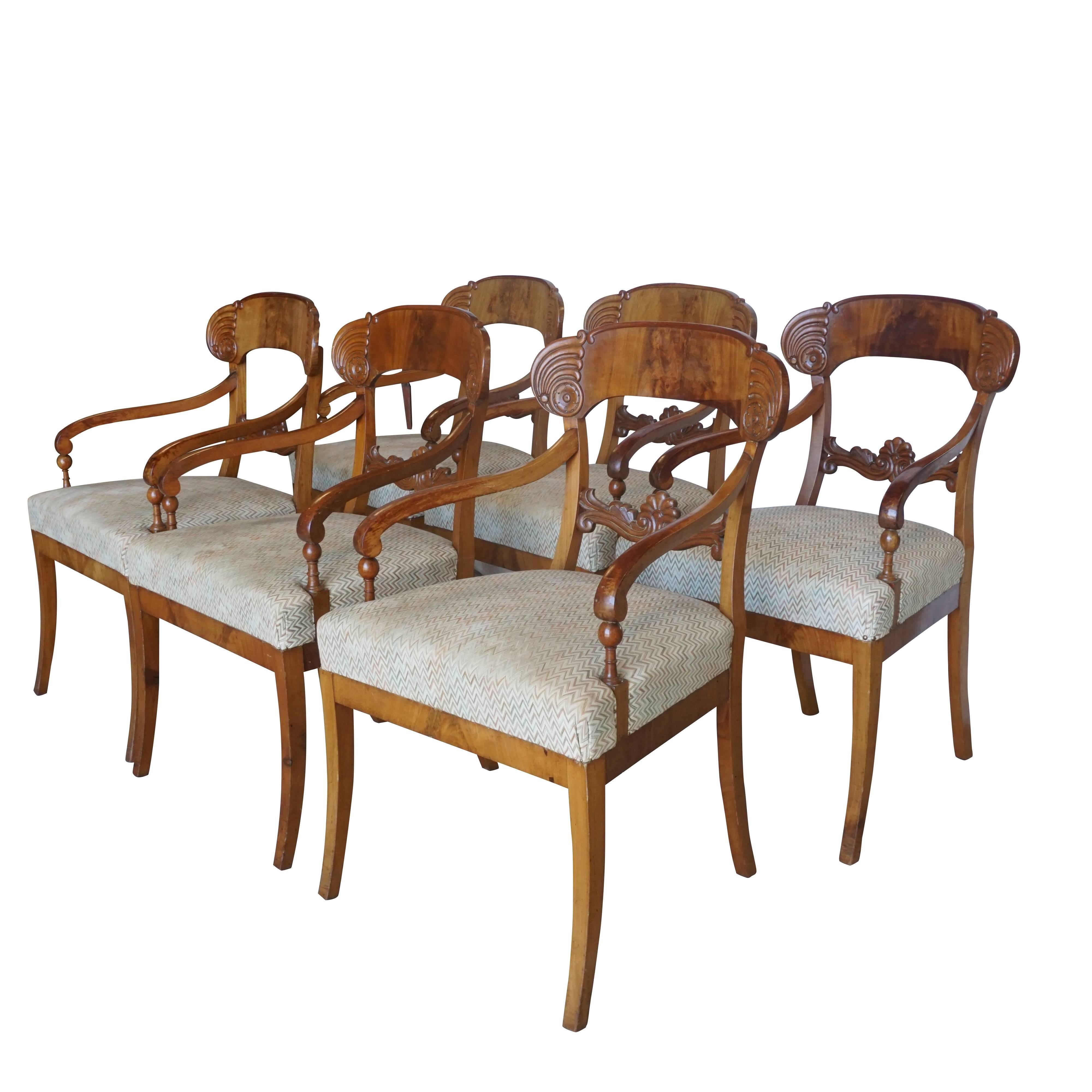 A light-brown, antique Swedish set of six Karl Johan period armchairs in good condition. The Scandinavian dining chairs are made of hand crafted Birchwood with shovel-shaped backrests, recessed volute arms, and newly upholstered seats and saber