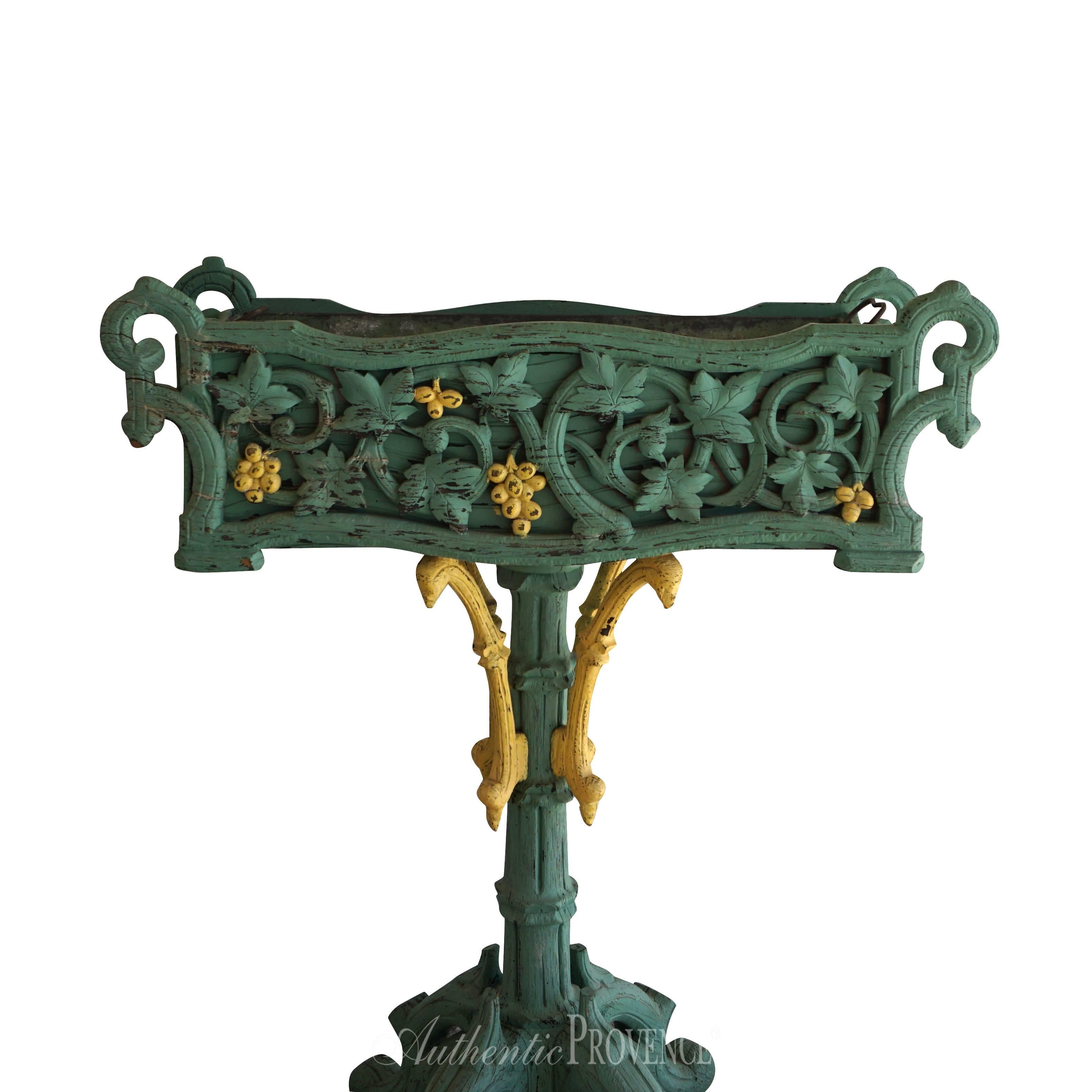 A rare rectangular plant stand made of wood with rich decor of grapevines and scrolls. Lovely worn painted green finish and yellow painted detail of grapes. Interior holding tole planter with lateral handles, circa 1840.