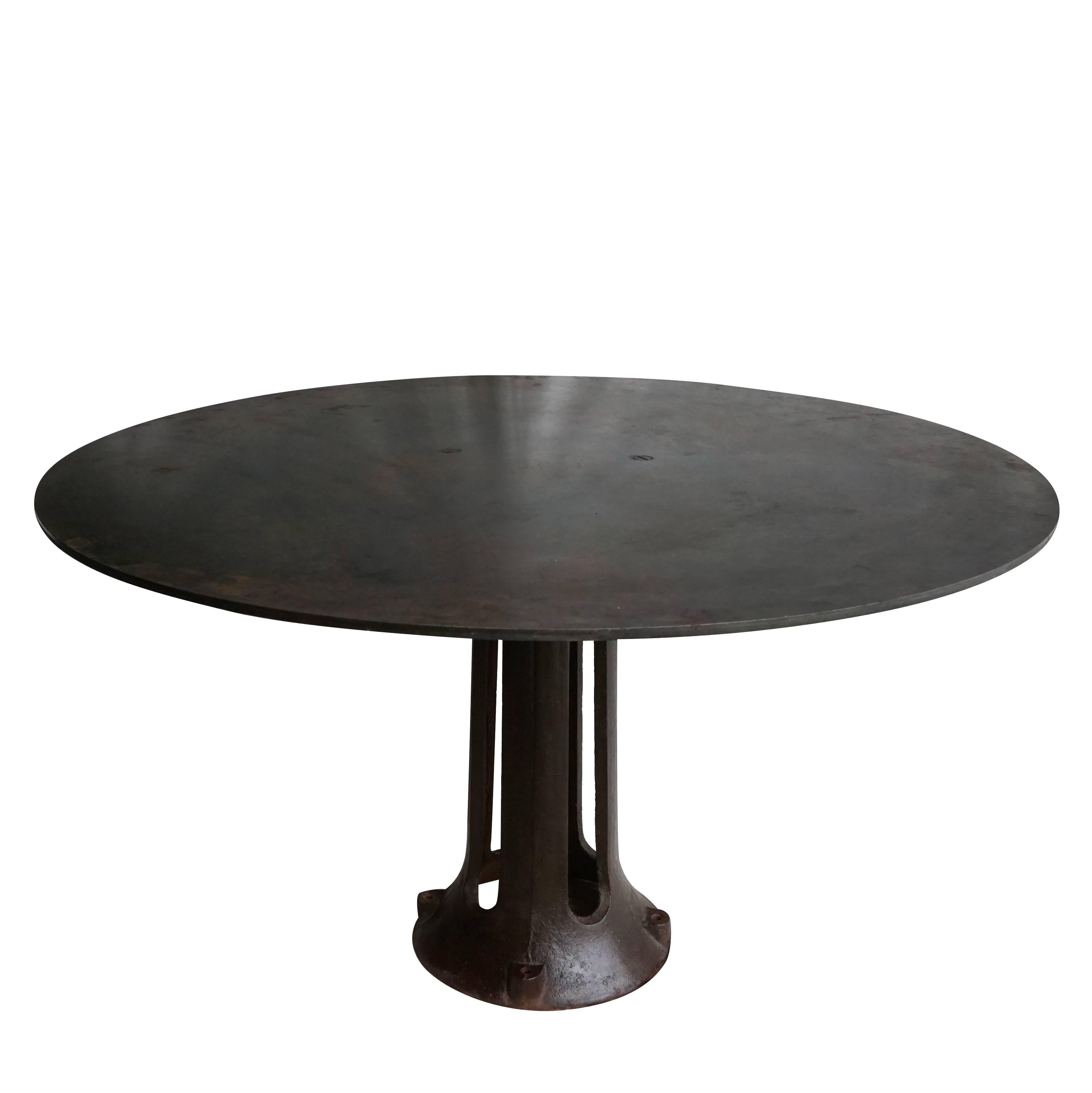 A round French industrial table on a round heavy tapered base made of cast iron with a distressed round table top in metal, circa 1920 France.