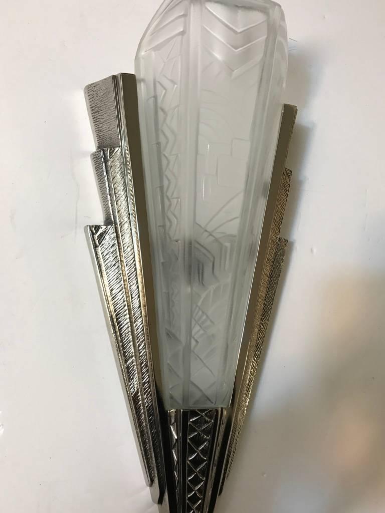 Set of four French Art Deco sconce signed by P. Maynadier. With clear frosted glass shades having intricate geometric motif details throughout. The shades are held by a matching polished silvered bronze geometric design frame. Has been rewired for