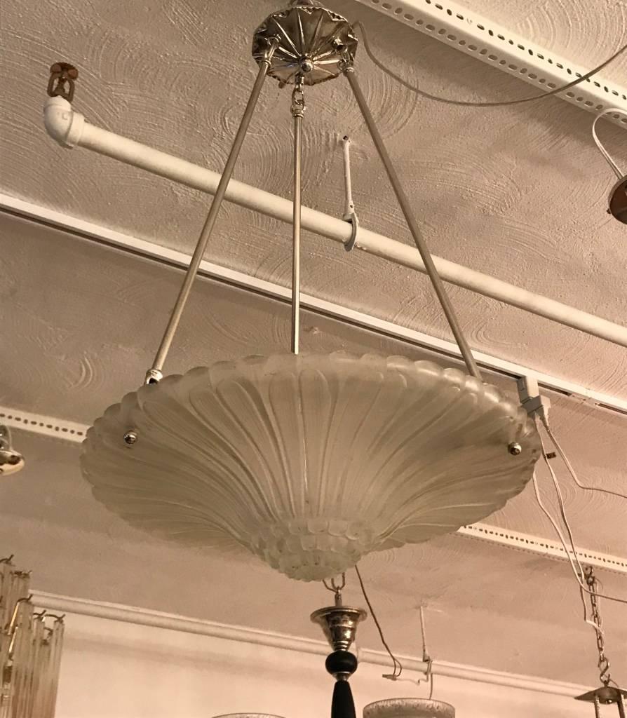 Stunning French Art Deco chandelier by Georges Leleu. With beautiful clear frosted glass bowl with geometric motif. Held by three nickel plated metal rods and matching ceiling plate. Has been rewired for American use. Three candelabra sockets.


 