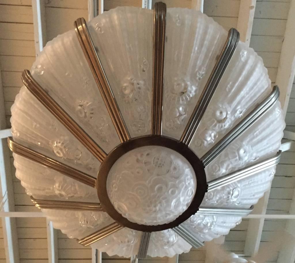 This incredible French Art Deco chandelier 
by Genet Et Michon, has flowered glass motif with 12 panels and center bowl. A must have for any collector, perfect for any large room with high ceilings. A grand chandelier from France during the Art
