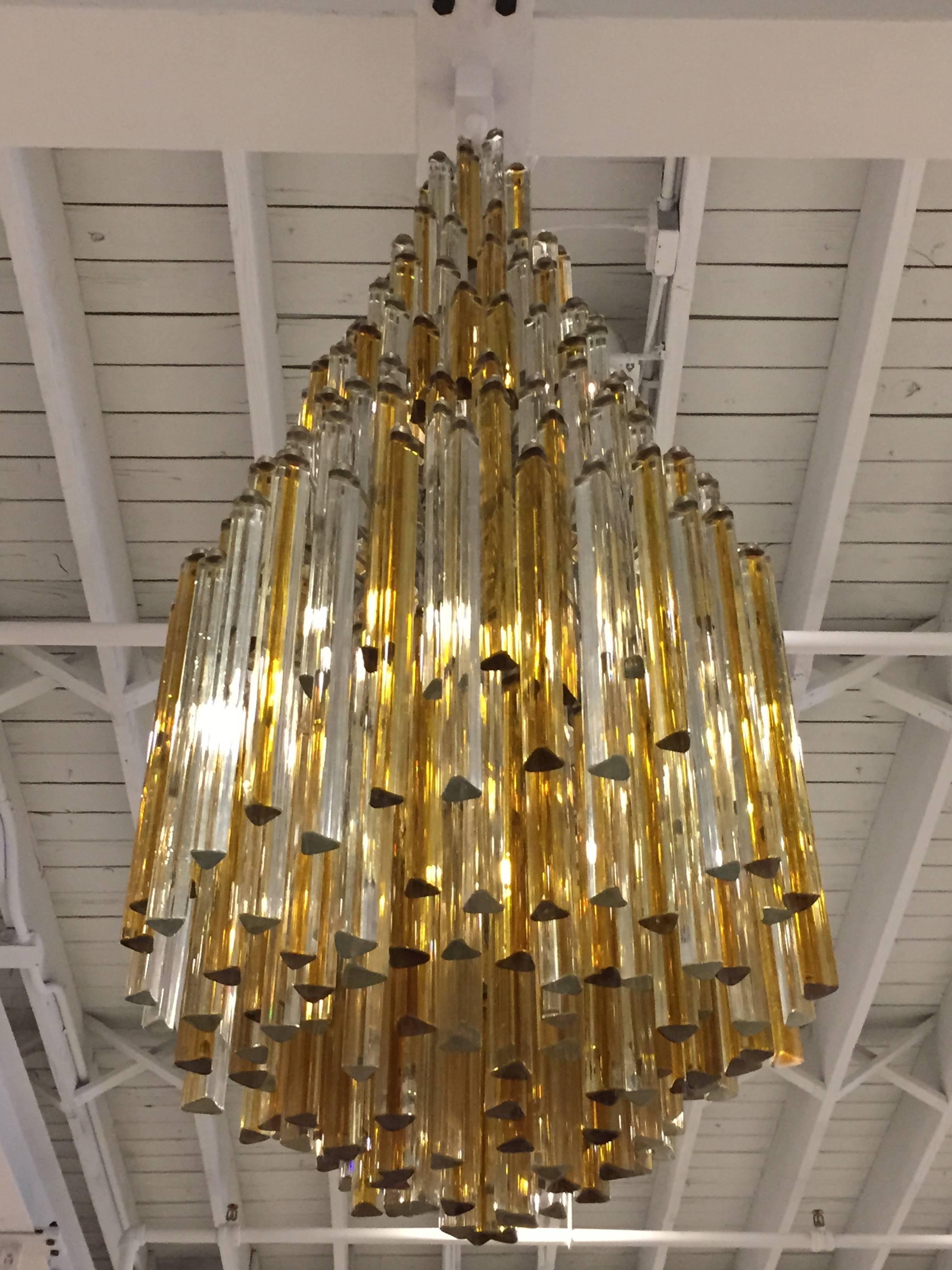 Italian Mid-Century Modern chandelier by Venini which has multi-tier cascading prisms. Consisting of gold and clear crystals, circa 1960. Any amount of chain or rod can be added for custom hanging length of the chandelier. Comes with matching