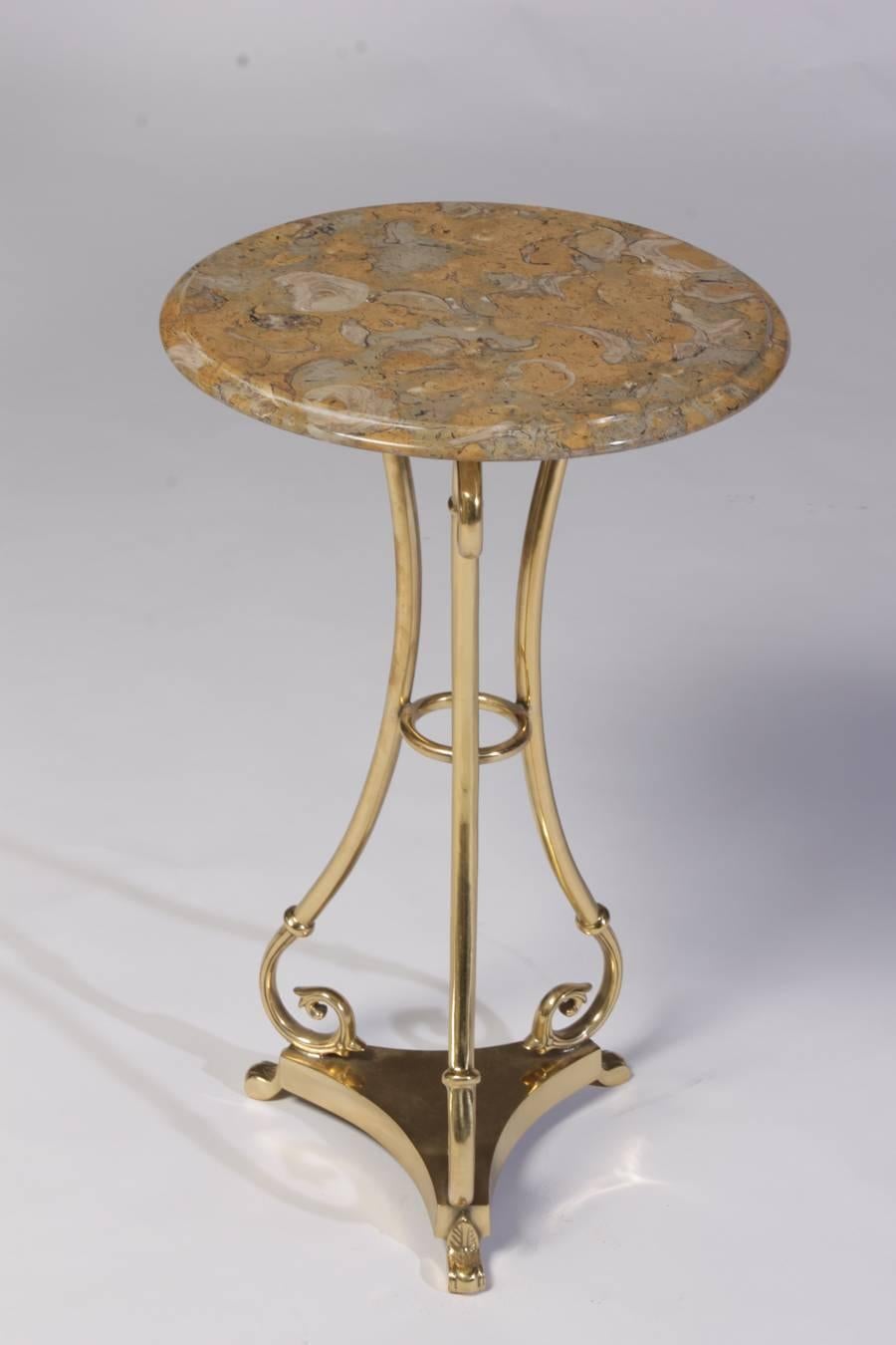 A pair of brass marble top gueridons having scrolling down swept legs raised on tri-corner plinths with stylized feet.
          