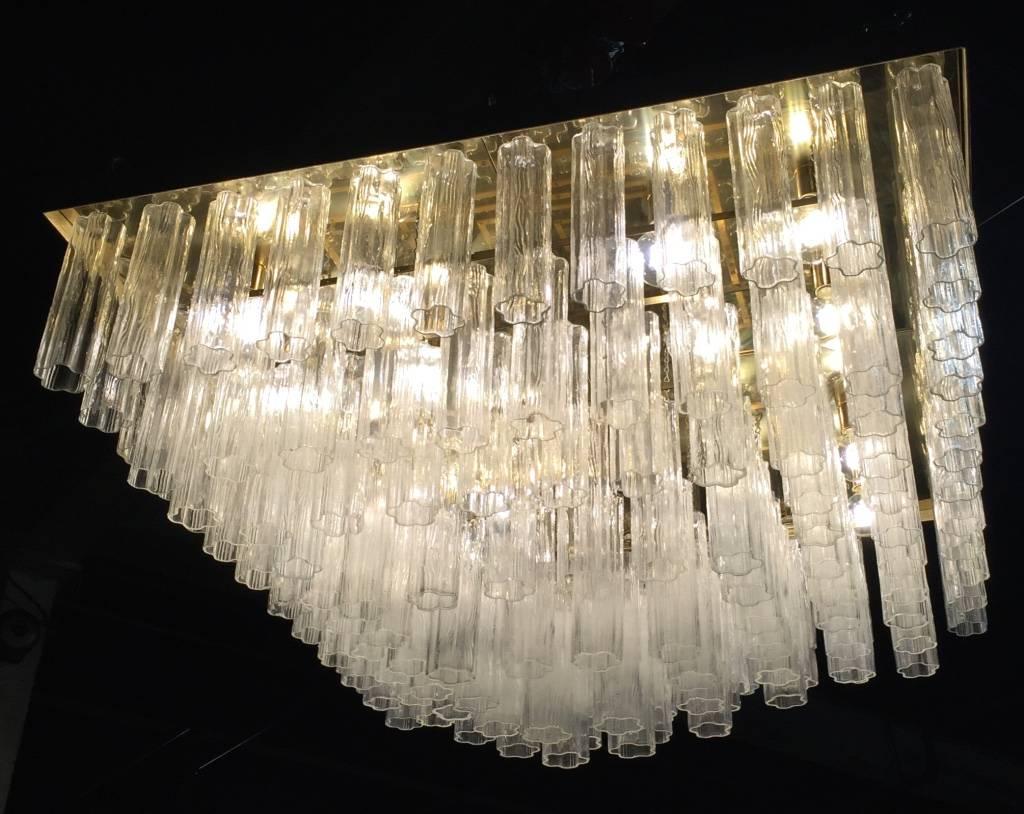 Italian Mid-Century Modern Tronchi chandelier comprising of a gold color metal frame containing five tiers of textured molded Tronchi glass tubes. Italian, circa 1960. Truly a statement chandelier that gives the perfect touch to your home or