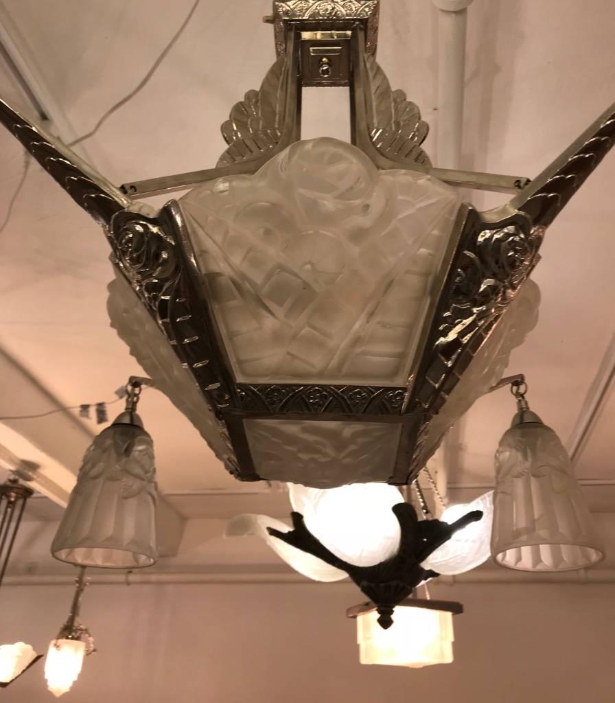French Art Deco chandelier signed by David Gueron Degue. Having geometric and floral four side panels with matching center and four tulips in clear frosted glass with polished details. Held by matching geometric nickel-plated design frame. Has been