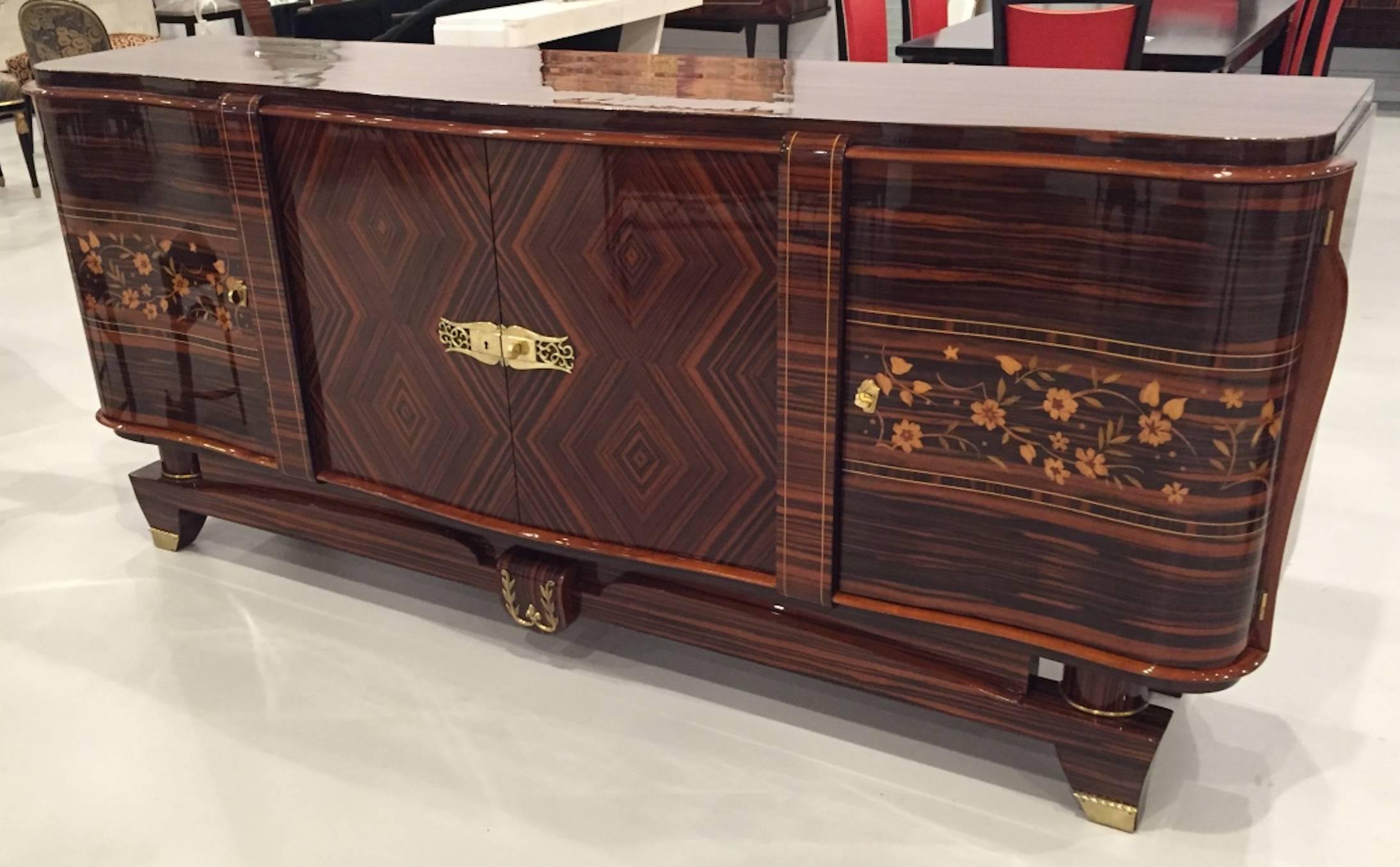 A spectacular French Art Deco Macassar “zigzag” buffet with geometric and floral motif. Having brass polished hardware that compliments the wood beautifully. Has been professionally restored with a high French finish. Perfect cradenza to add to your