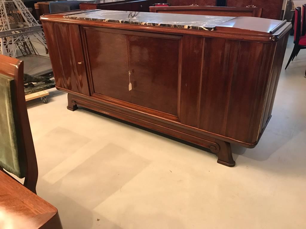 Stunning French Art Deco numbered (2455) buffet by designer Gaston Poisson. This sideboard having beautiful mahogany wood and marble top is accented with keys that have Gaston Poisson's initials GP. The doors open to reveal many drawers and shelves