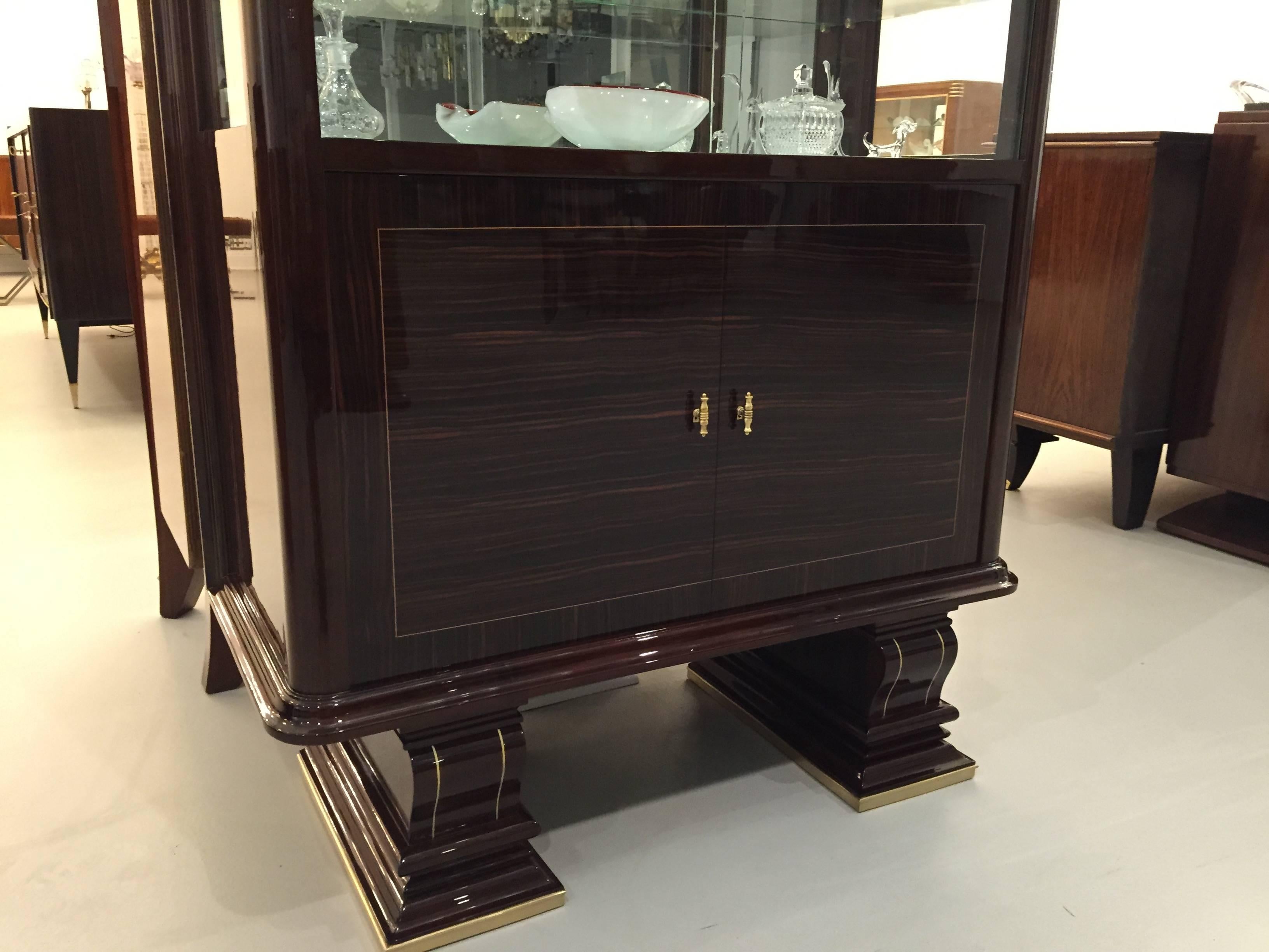 This French Art Deco vitrine with faux ivory trim has been professionally refinished by a third generation restorer. Having glass sliding doors with glass shelves. Cabinet doors open to reveal a dry bar. Very stunning! 

circa 1930s. 



 