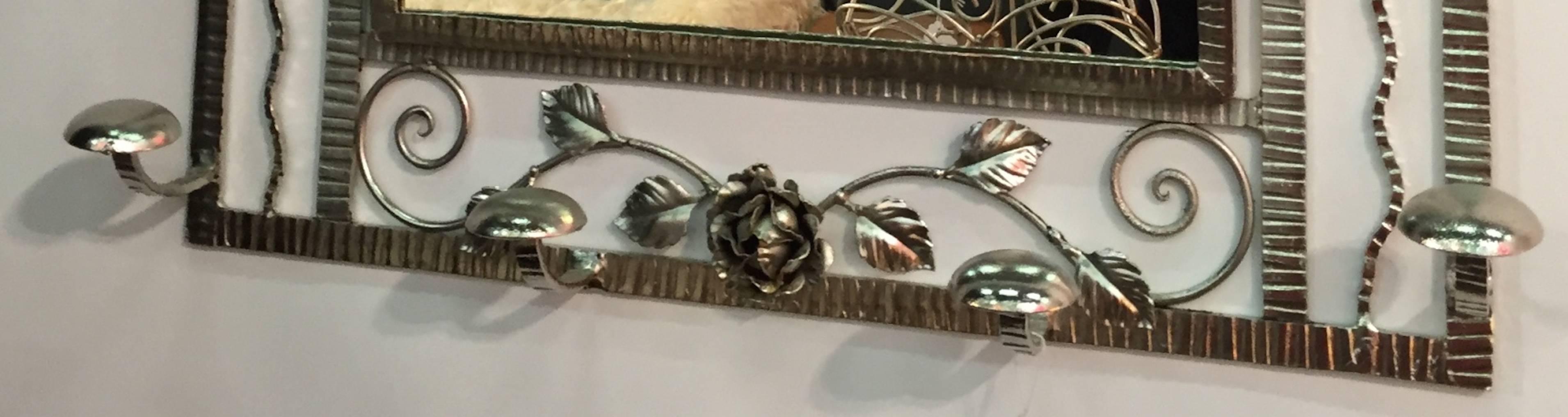 This amazing French Art Deco silver plated coat rack with central mirror and hat rack has beautiful details including a rose at the bottom. Having six coat hangers with along with a place to hold hats. 

circa 1930s 