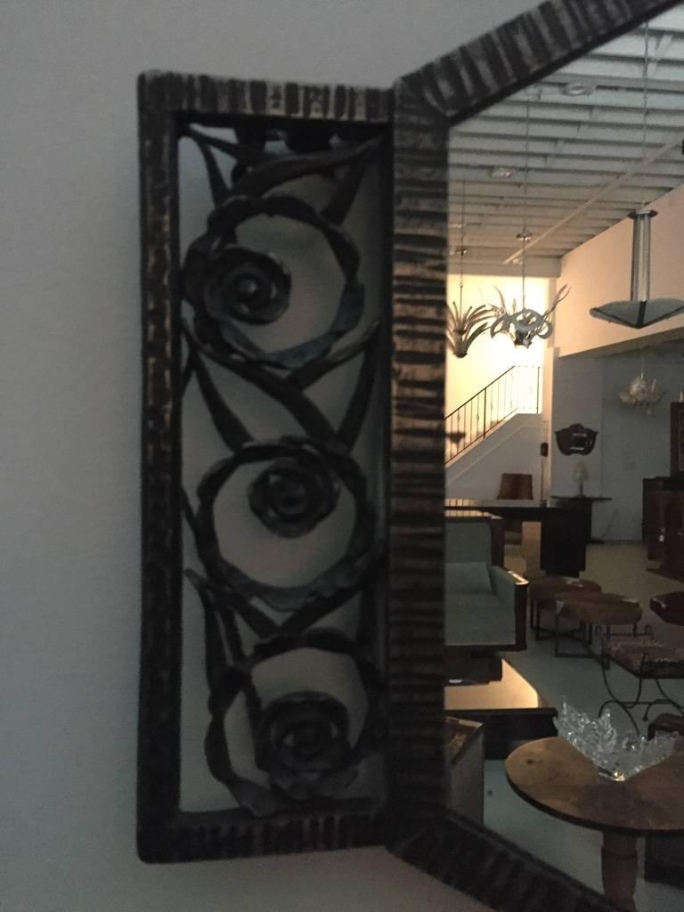 A beautiful hand-forged wrought iron French Art Deco wall mirror with flower motif and ribbed detail. Very stunning having deco lines. 

  