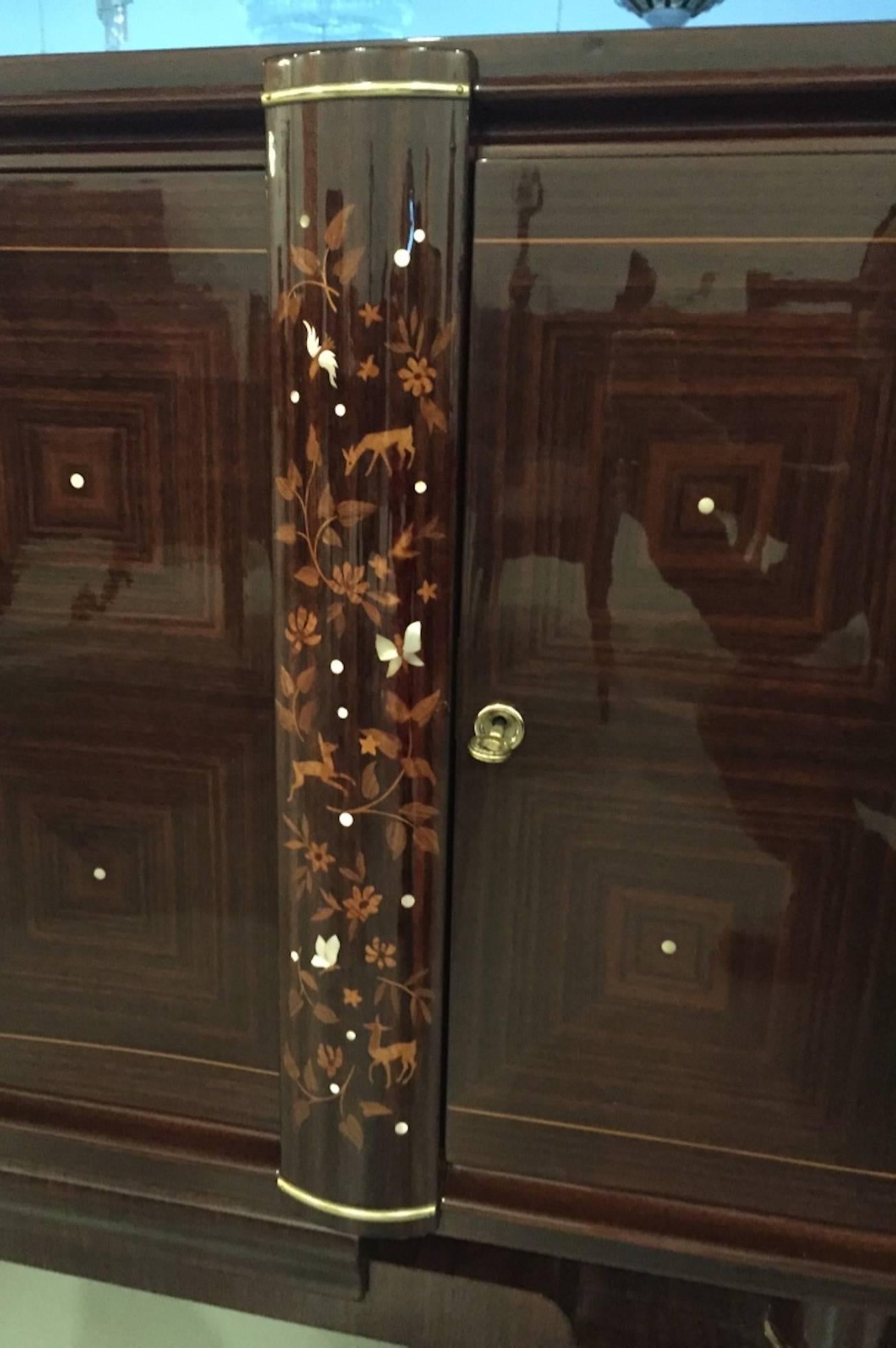 French Art Deco Jules Leleu buffet  Having beautiful mother-of-pearl inlay with gorgeous marquetry. Bronze detail highlighting the wood beautifully. The craftsman ship is incredible, the inside of every door has floral marquetry along with