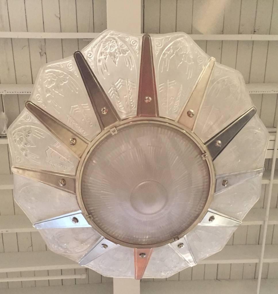 This incredible grand French Art Deco chandelier signed by Lorrain Nancy, has flowered glass motif with 12 panels and center bowl. Geometric motif polished details mounted on a silvered bronze frame with a streamlined design.