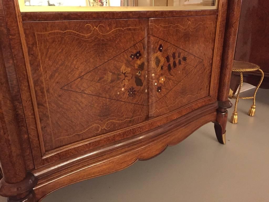 Rare stunning French Art Deco burl Amboyna vitrine or dry bar. Beautiful mother-of-pearl inlay with gorgeous marquetry. Sliding glass doors open for plenty of space for display. In the style of Jules Leleu.
 
 


  