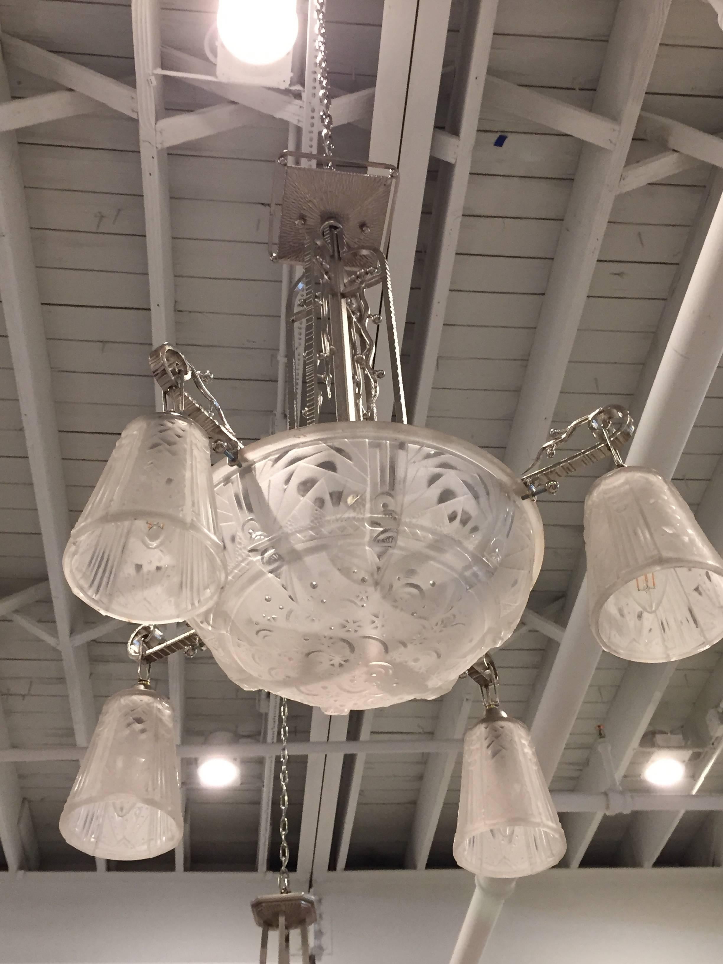 French Art Deco chandelier signed by Muller Frères with four tulips surrounding the center globe. Beautiful geometrical and floral motif. Every piece of glass is signed Muller Frères. The frame has been plated in polished nickel and re wired for