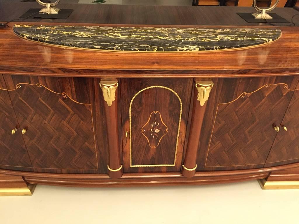 Very impressive French Art Deco walnut five door buffet. Having beautiful mother-of-pearl and marquetry inlay. Gold hardware with a stunning piece of marble on top. Doors open to reveal plenty of storage.