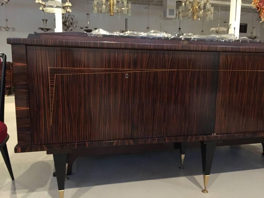 This stunning French Art Deco exotic Macassar ebony buffet or credenza, circa 1940s. Has a dry bar with a lazy Susan. Interior finished in lemonwood and black lacquered legs. Perfect for any room in your house.
