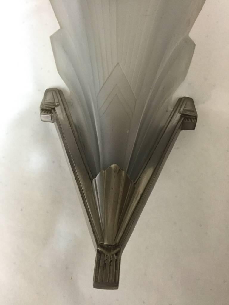 Coppia di applique francesi Art Decor firmate da Muller Freres in vetro smerigliato trasparente modellato e decorato con motivi geometrici. Ogni paralume è montato in cornici di bronzo. Le lampade possono essere placcate nuovamente su richiesta.