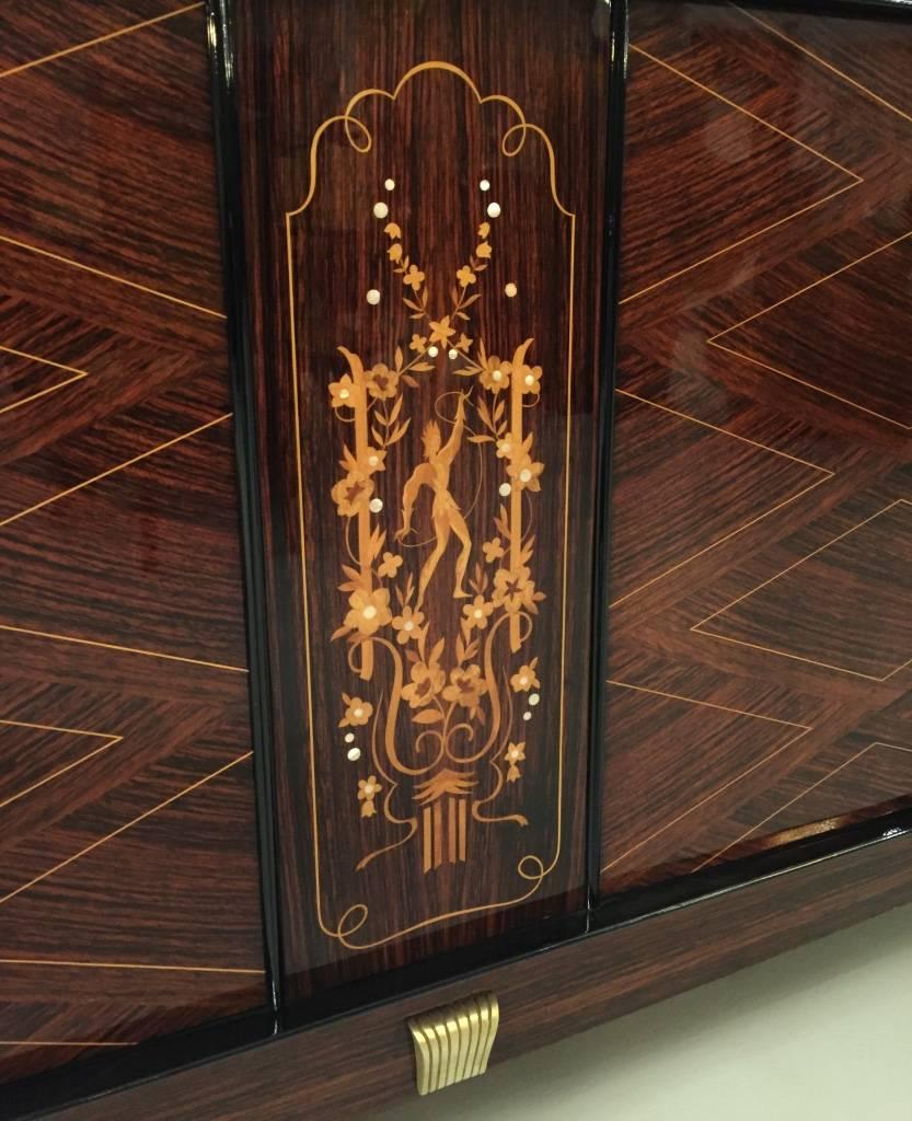 Stunning French Art Deco Palisander (Brazilian rosewood) buffet having beautiful mother-of-pearl inlay with gorgeous marquetry. Bronze detail highlighting the wood beautifully. Elaborate center panel, adorned with bronze hardware. In the style of