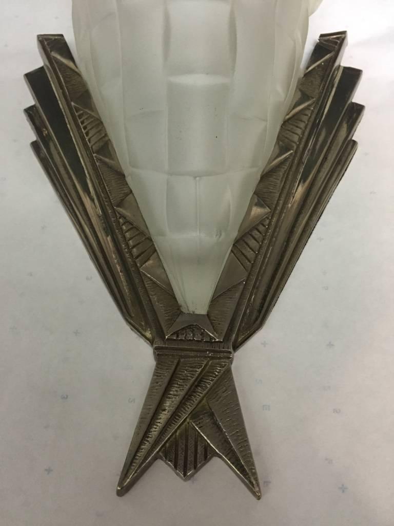 A pair of French Art Deco wall sconces by the French artist Degue. With molded clear frosted glass decorated with floral motif. Each shade is marked Degue, mounted in bronze frames with beautiful geometric detail.  Re-plating upon request.