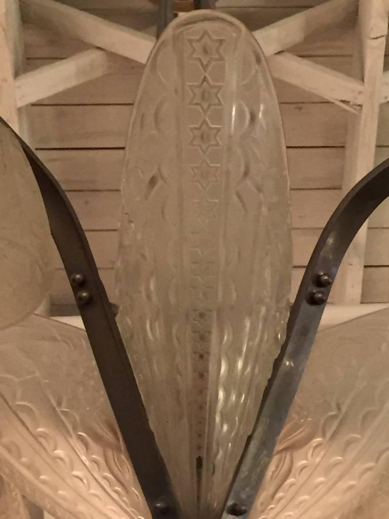 Stunning French Art Deco chandelier by Donna Paris. Having four shades in clear frosted glass and surrounded by four tulips. Beautiful floral motif and stars. 

Can be replated upon request.