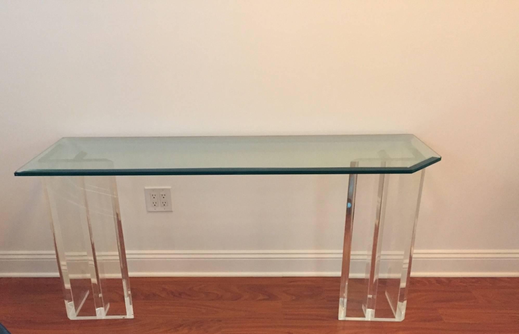 Mid-Century Modern console table with Lucite dual base and glass top. Having a asymmetrical glass top. Perfect for any room in your house, adding the perfect decor.