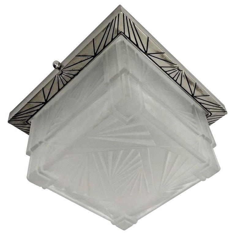 Stunning French Art Deco flush mount or sconce. Clear frosted glass with geometric motif. Mounted on a matching nickeled bronze decorative design frame. Re-plating upon request. 

Dimensions as a flush mount.
H 6 inches.
W 10.25 inches.
D 10.25