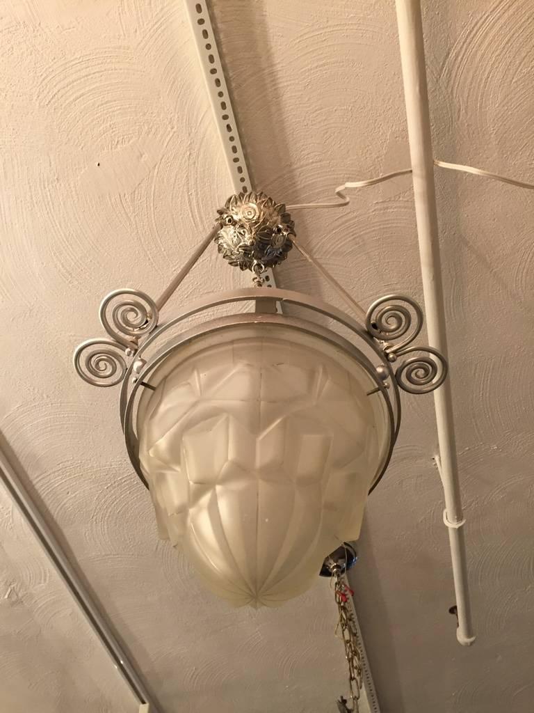 Stunning French Art Deco chandelier signed by Degue. Clear frosted glass with geometric motif. Mounted on a matching nickeled bronze decorative design frame with a floral ceiling plate.