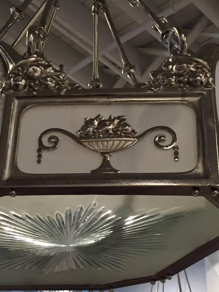 Lampadario Art Deco francese in bronzo nichelato. Ha un vetro bianco latte e un motivo floreale. Molto elegante, aggiunge un perfetto arredamento Deco alla tua casa. Emette una bellissima quantità di luce.