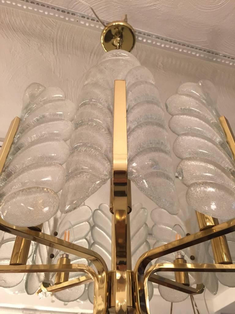 Superbe lustre en laiton de style moderne du milieu du siècle avec huit magnifiques pédales en verre. Toute quantité de chaîne peut être ajoutée pour une longueur de suspension personnalisée du lustre. 

Hauteur sans chaîne 17 pouces.