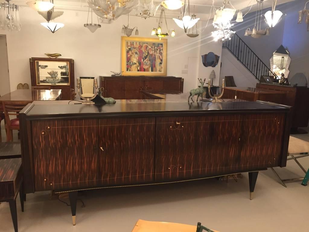 Stunning French Art Deco sideboard with mother-of-pearl inlay. Having a center drop down dry bar. Brass hardware that accents the wood beautifully.