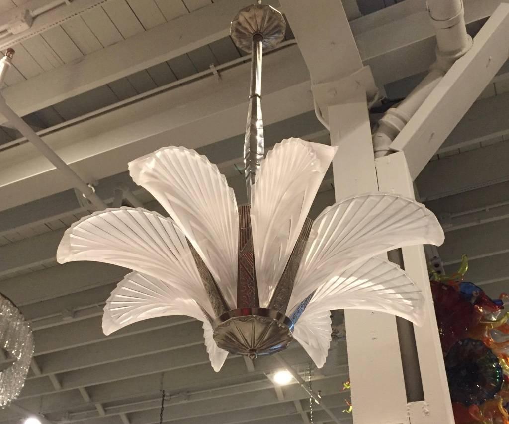 Stunning French Art Deco "feather" chandelier. Having eight frosted glass panels with ribbed geometric motif. Held by a nickeled bronze multi-tiered skyscraper geometric design frame. The frame has been plated in nickel and re wired for