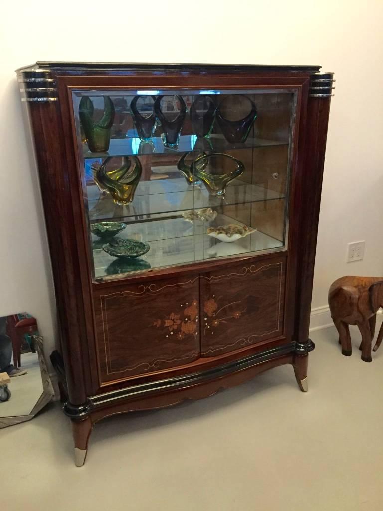 Stunning French Art Deco vitrine or dry bar. Having beautiful mother-of-pearl inlay with gorgeous marquetry. With black accents and silver hardware. Sliding glass doors open for plenty of space for display. In the style of Jules Leleu.