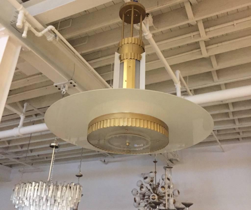 Stunning Art Deco grand theater chandelier. Having a ribbed motif on the brass metal frame. The 48 inch diameter gives a majestic feel to the chandelier.  The height can be adjusted upon request. Making it the perfect focal point for a lobby or very
