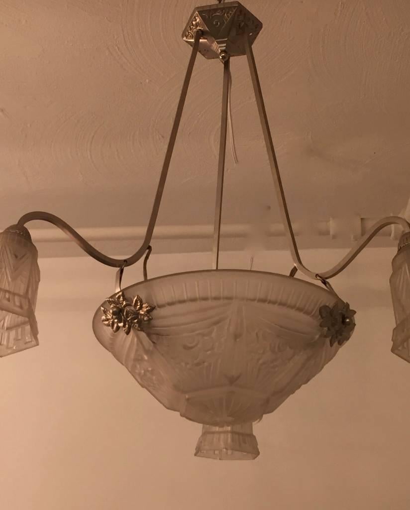 French Art Deco chandelier with floral and geometric motif. Center bowl having three tulips hanging adjacent. The frame has been plated and re-wired for American use.