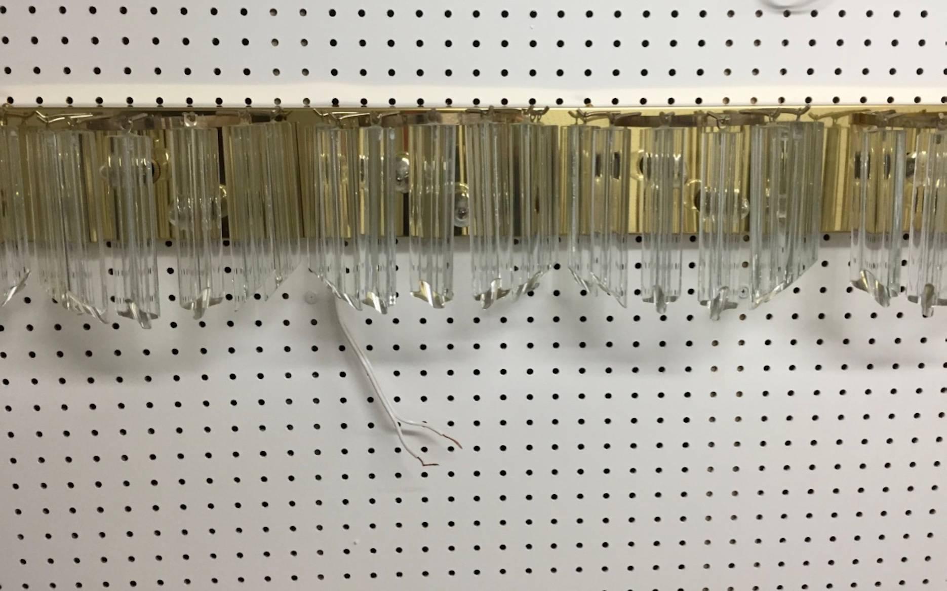 Italian Mid-Century Modern 52 inch horizontal sconce by Venini. Having a brass frame with beautiful 6 inch glass prisms.