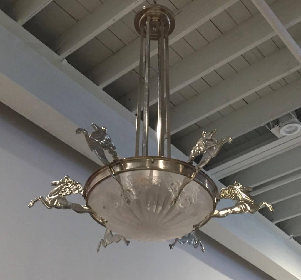 Stunning French Art Deco chandelier signed by Degue. Having six deco mythical horses surrounding the center glass bowl. With six rods that connect to a gorgeous deco ceiling plate.