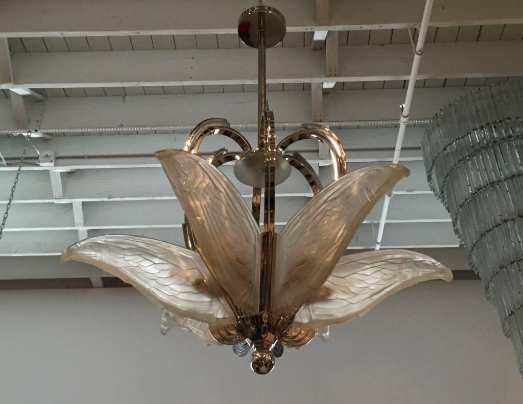 Stunning French Art Deco geometric chandelier by P. Maynadier. Having six molded clear frosted glass geometric flying bird panels. The polished nickel frame having geometric deco details through out. The height can be adjusted upon request. 