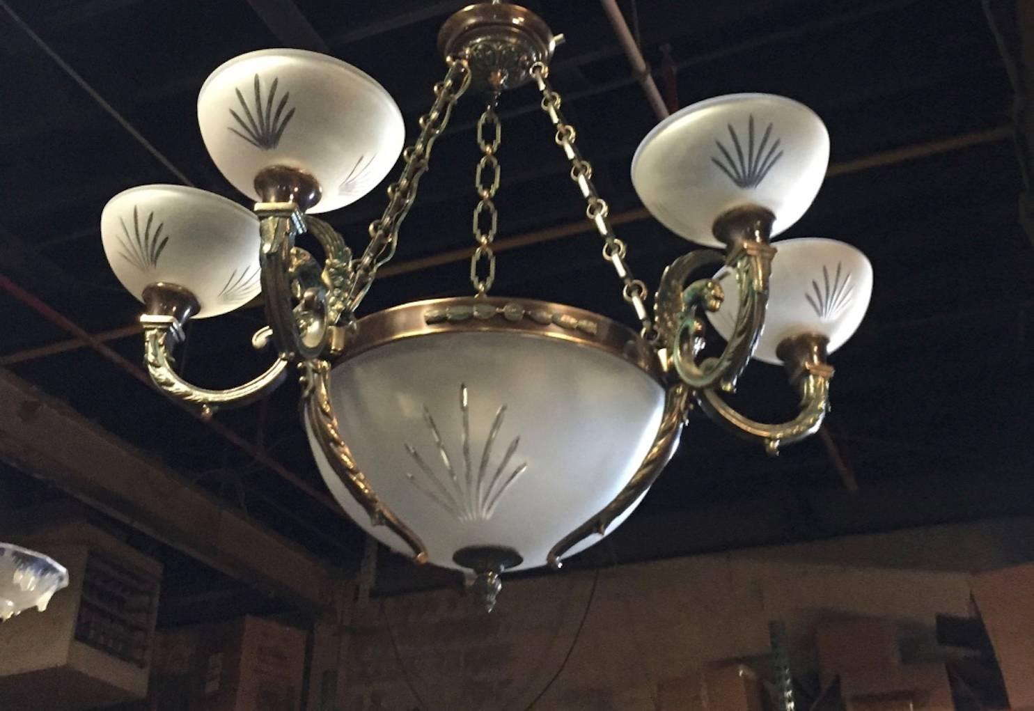 Pair of Gothic nine-light crystal and bronze domed chandelier depicting gargoyle motif. Having one large centre glass bowl surrounded by six smaller glass bowls with a gargoyle motif in the bronze frame. Having a beautiful green patina on the bronze.