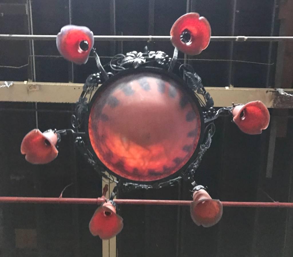 French Art Deco chandelier. Having a center glass bowl with six surrounding tulips in red and blue colored glass. With floral details on the frame. Re-plating upon request.