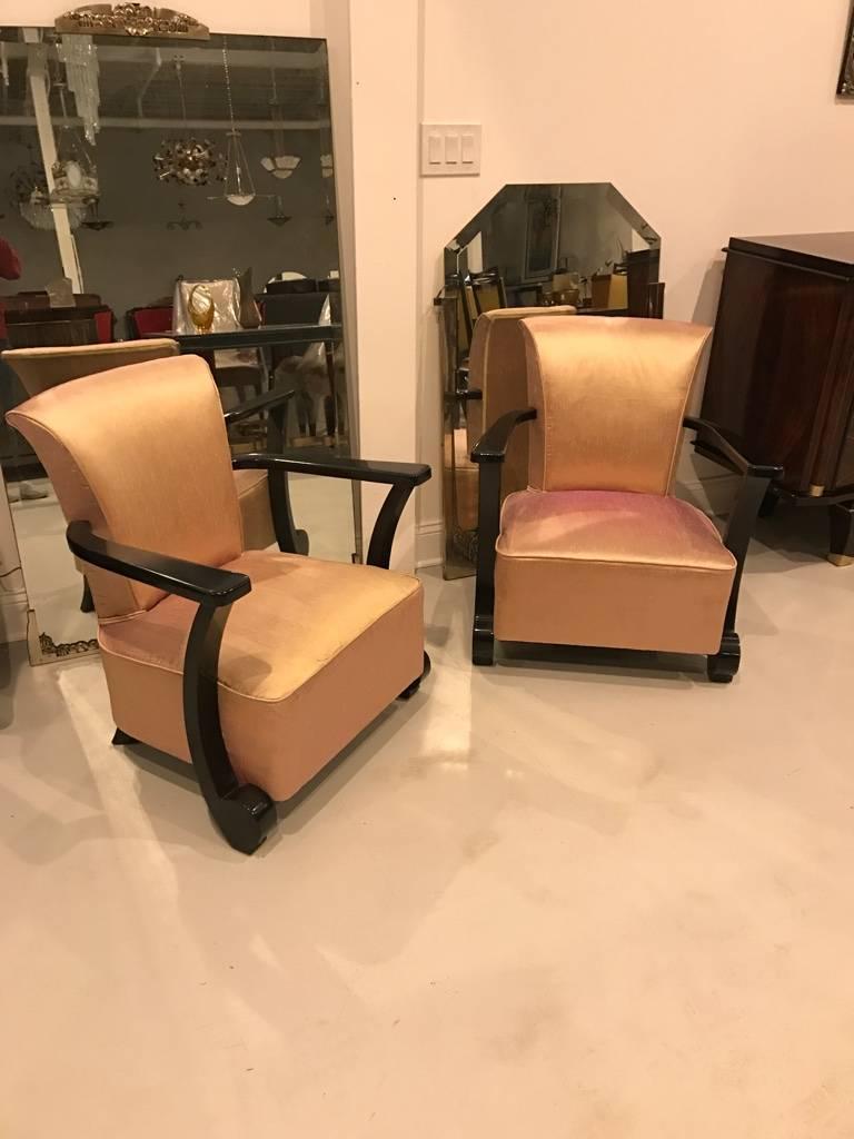 Stunning pair of French Art Deco club chairs. Having beautiful deco ebony lacquered legs and pink upholstered fabric.