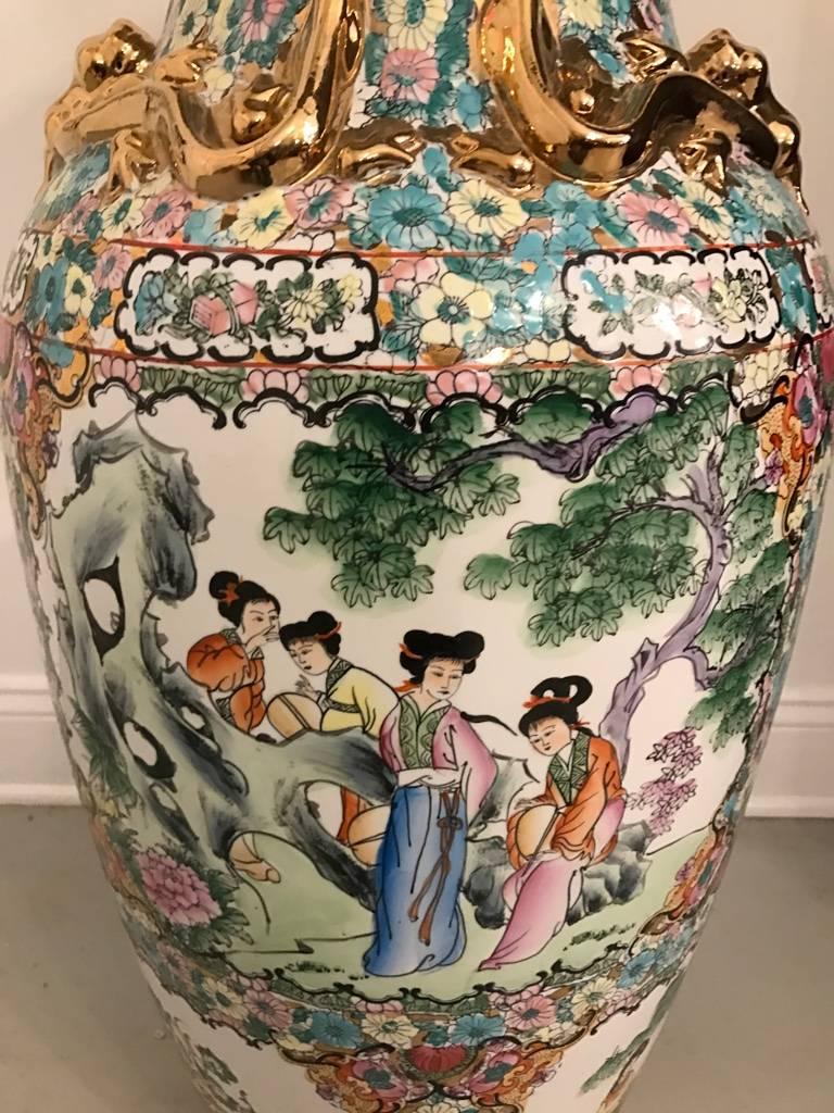 Impresionante jarrón de porcelana tamaño palacio con detalles florales y dorados. La escena floral es preciosa, con colores muy vivos y muchos detalles. Junto con pájaros voladores y otros motivos asiáticos.