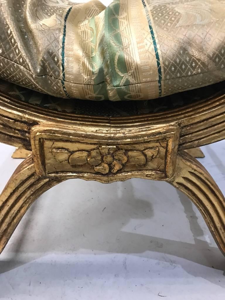 Gilt wood bench with hand-carved details. Having a matching pillow and tassels.