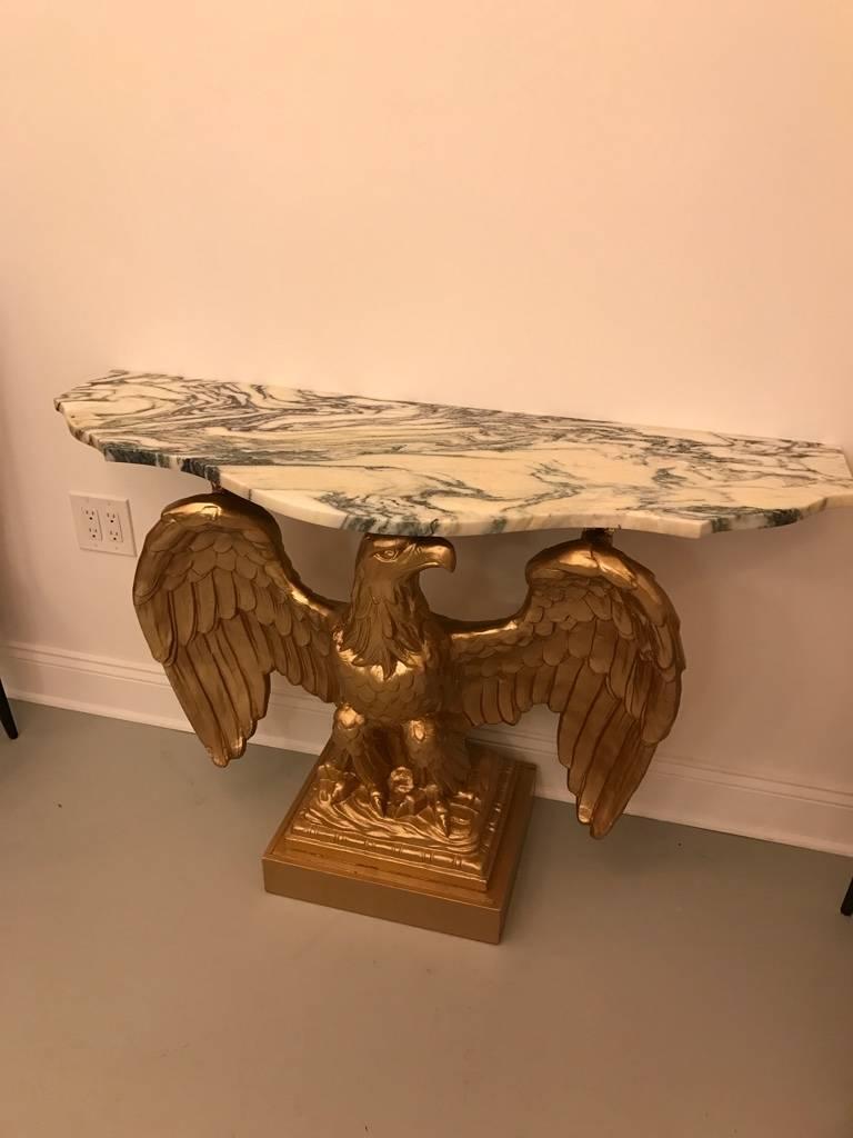 American Eagle gilt wood console table with marble top. Hand-carved wood has been gilded. The eagle holds the marble top.

