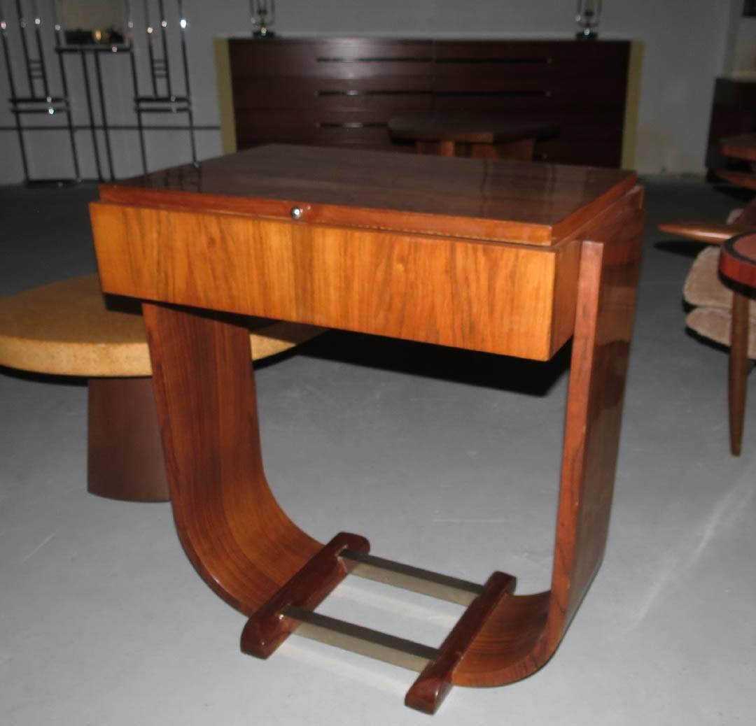 Stunning French Art Deco console is from 1930s. Constructed of Brazilian rosewood and Brazilian rosewood veneers. The lop lifts to reveal a mirror and three storage spaces. The two sides curve inward at the base where rosewood feet are connected by