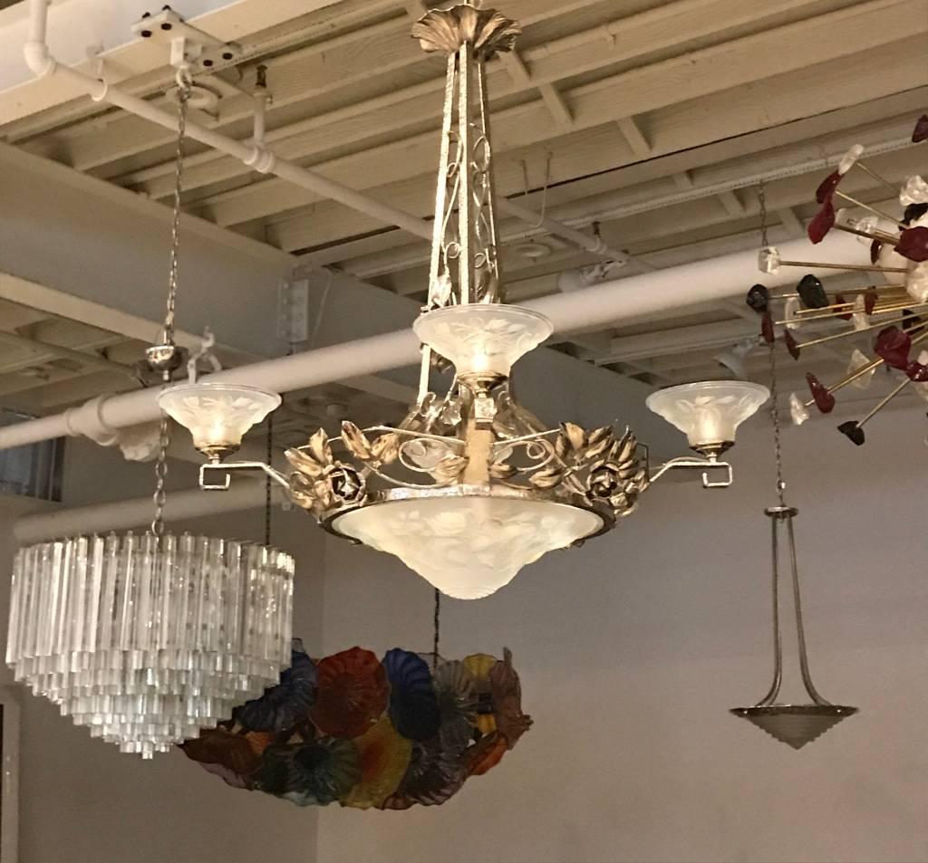 French Art Deco chandelier signed by P. Maynadier. With four opalescent glass shades surrounding a center opalescent bowl having intricate floral motif details throughout. Shades are held by silvered design frame.