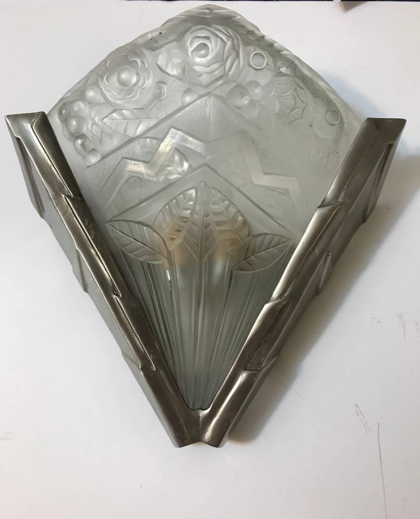 Stunning pair of French Art Deco sconces by Jean Noverdy. Having clear and frosted glass slip shades with geometric and floral motif. Each shade is held by a nickel bronze multi-tiered skyscraper geometric design frame. Re plating upon request.